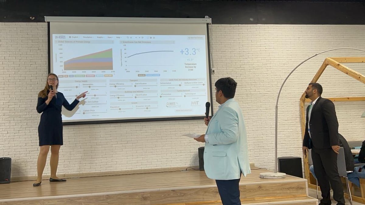 Asish Singh presenting a climate policy simulation on stage